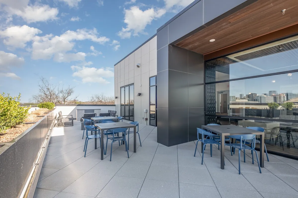 A stylish rooftop lounge with comfortable outdoor seating, set against the backdrop of Nashville’s city skyline. The landscaped edges and open sky create an inviting ambiance for evening cocktails, city views, and intimate conversations.